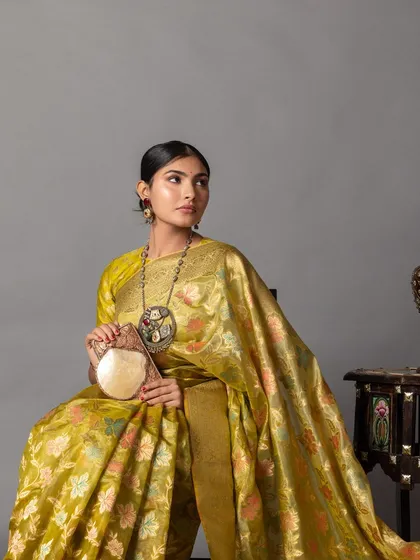 A different pose in the handloom saree, this time with a handcrafted bag. This shows how to accessorize traditional sarees with unique, artisanal pieces.
