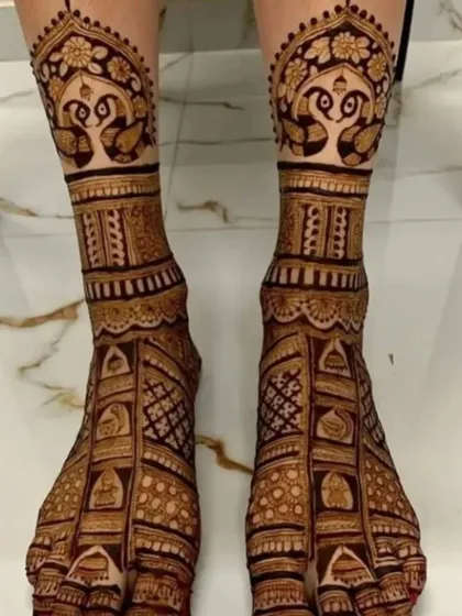A rich and intricate foot design with peacock figures and dense patterns, perfect for a bride.