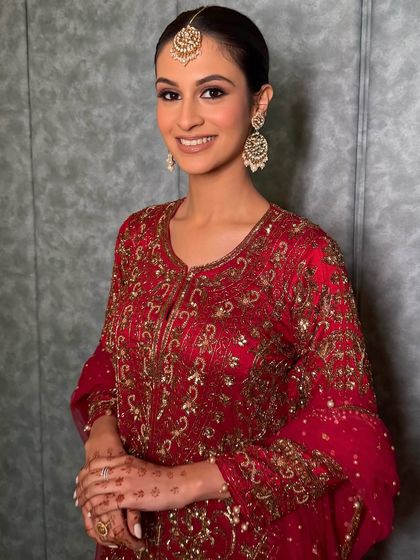 Serving a bold, sultry, and moody maroon look. The makeup features a soft smokey eye and a clean, radiant base that lets the rich color of the outfit shine.