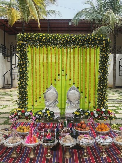 A simple yet elegant outdoor setup with a bright lime-green backdrop and yellow floral garlands.