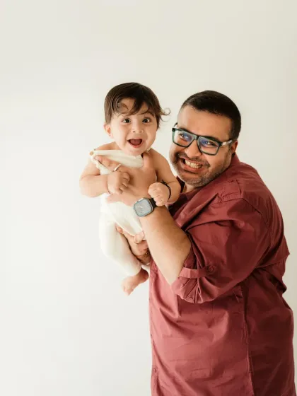 A father and his baby share a moment of laughter. This candid shot perfectly captures the joy of fatherhood.