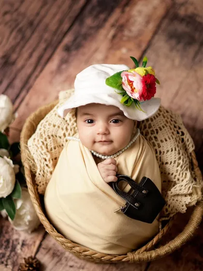 This little fashionista is ready for her close-up! We had fun with this newborn pose, adding a stylish hat and a tiny handbag for a playful and unique shot.