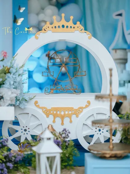 A close-up of the Cinderella-inspired carriage prop. This piece served as a beautiful dessert stand and a central element of the fairytale decor, detailed with elegant white and gold accents.