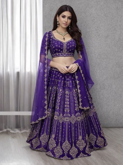 A gorgeous lehenga in a rich royal purple, adorned with intricate gold embroidery. This is a regal and elegant choice for an evening wedding function or reception.