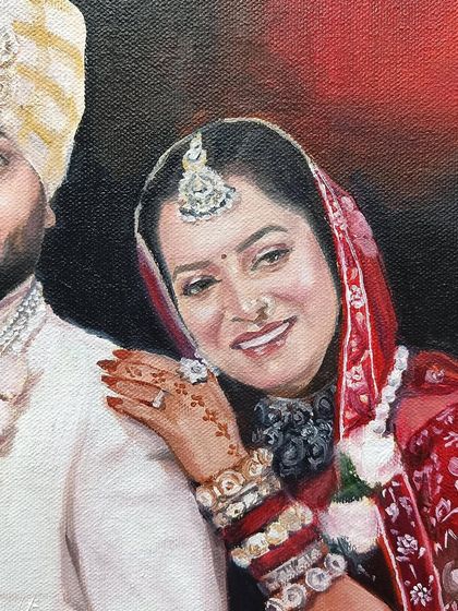 Close-up of the bride's face, showing the detail in her jewelry and the henna on her hand.