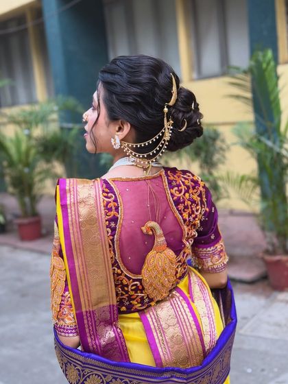 A side profile of the traditional Maharashtrian updo. This angle shows how the chained accessory, or 'kaan vel', connects from the bun to the ear, adding another layer of traditional elegance.