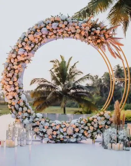 We create beautiful, trendy photo opportunities for you and your guests. This circular floral arch, set against a backdrop of palm trees, served as a popular selfie booth and a stunning piece of decor for a daytime event.
