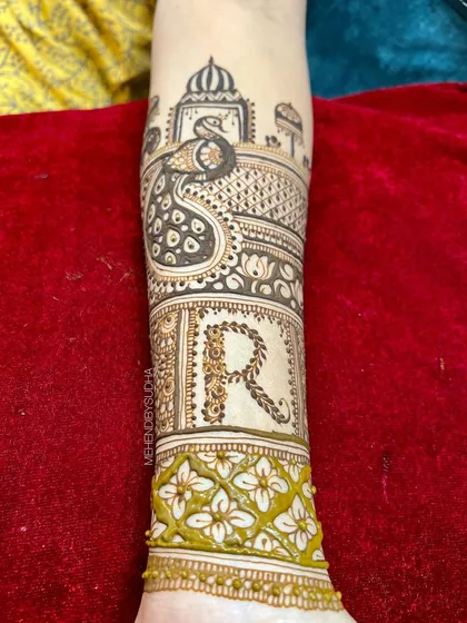 The groom's initial 'R' is crafted with a rope-like texture, surrounded by floral patterns and a majestic peacock, symbolizing beauty and grace.