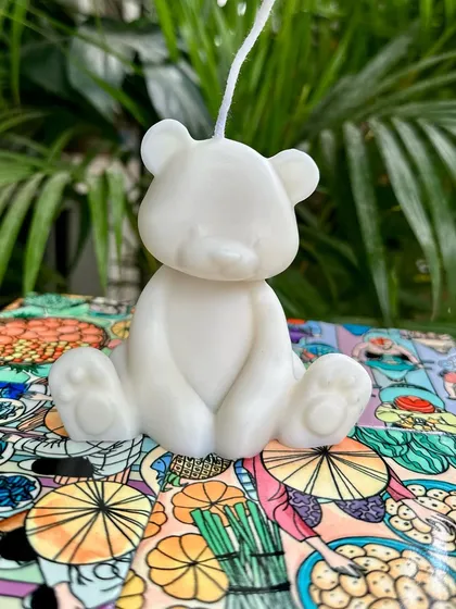 A simple and cute teddy bear soy candle, perfect for baby showers or as a sweet decorative piece.
