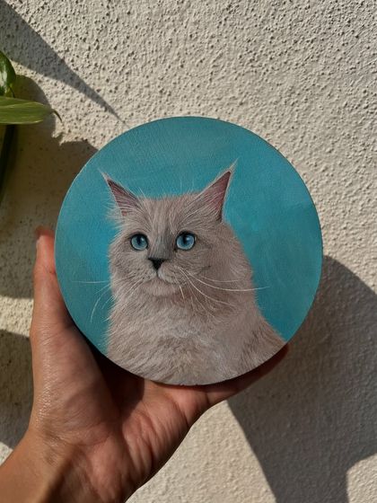 This beautiful Ragdoll cat with stunning blue eyes was painted on a round wooden canvas. The simple, solid background really makes the subject pop.