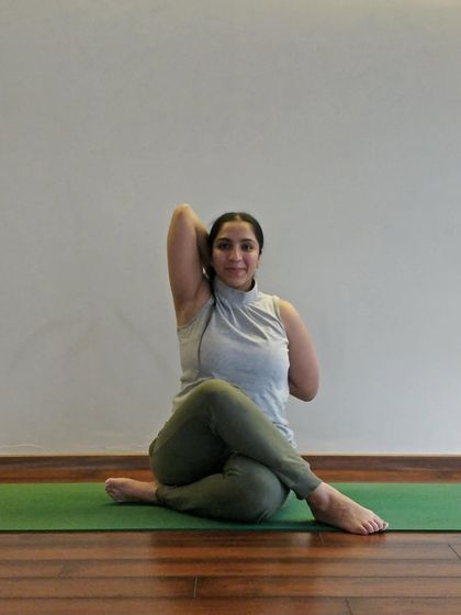 A student finds her joy in Gomukhasana (Cow Face Pose), a deep shoulder and hip opener.