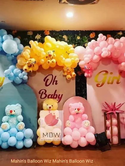 A playful "Oh Baby" gender reveal party with a teddy bear theme. The setup is split into blue and pink sections, with adorable teddy bears and balloon arches for each side.