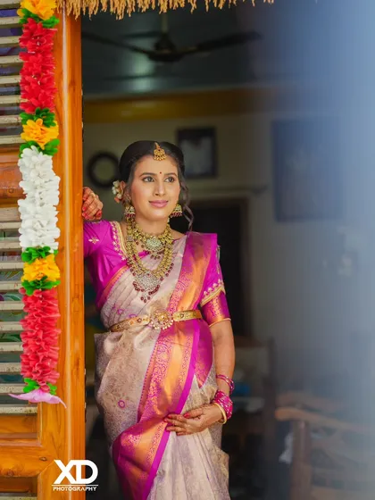 A candid moment captured at the entrance of the baby shower venue, with traditional flower garlands framing the doorway.