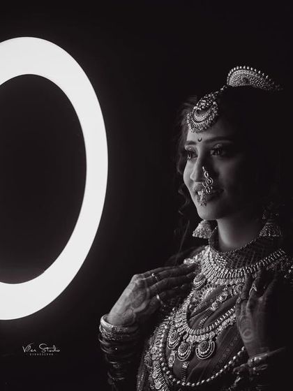 A dramatic black and white bridal portrait using a ring light. The high contrast and focused light create a moody and sophisticated image that highlights the bride's features and jewellery.