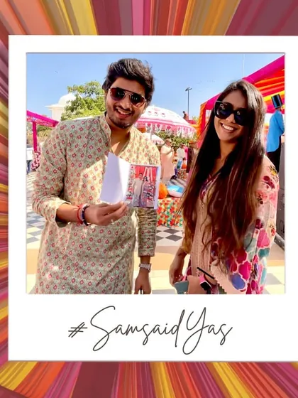 A guest proudly showing off their instant photo print. It's a tangible memory from the #SamsaidYas wedding that they can take home immediately.