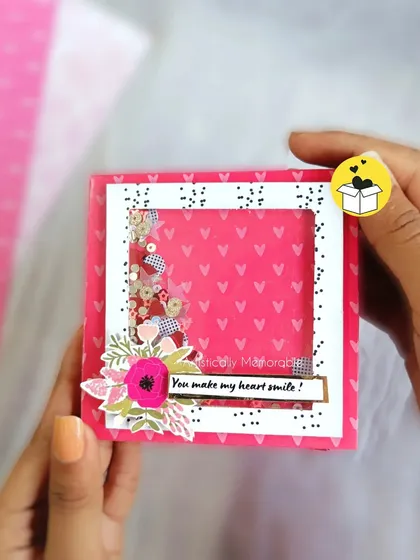 Holding the mini scrapbook to show its compact size and the cute shaker element on the cover.