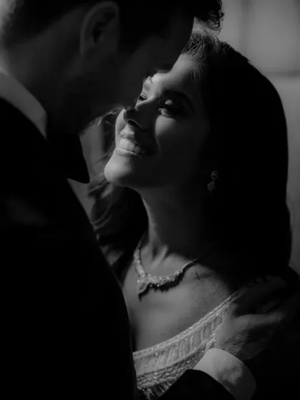 An intimate black and white close-up of the couple during their reception. The soft lighting and genuine smiles make this a beautifully romantic and candid shot.