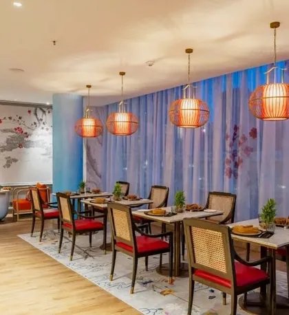A section of the Oriental Pavilion featuring a hand-painted mural and elegant lantern-style lighting. The design uses a palette of deep reds and blues to evoke a sense of tranquility and sophistication.