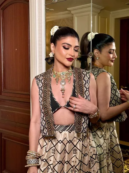 A reflective moment captured in the mirror. This shot showcases the beautiful profile and the intricate details of the hairstyle and makeup.