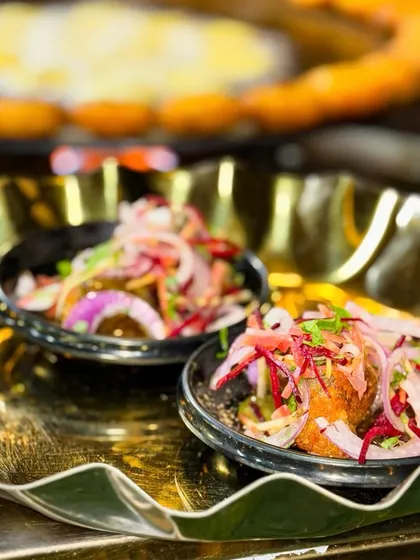 Another look at my Karari Tikki chaat, served on a golden platter. The contrast of the colourful toppings against the dark bowl makes for a very appealing presentation.