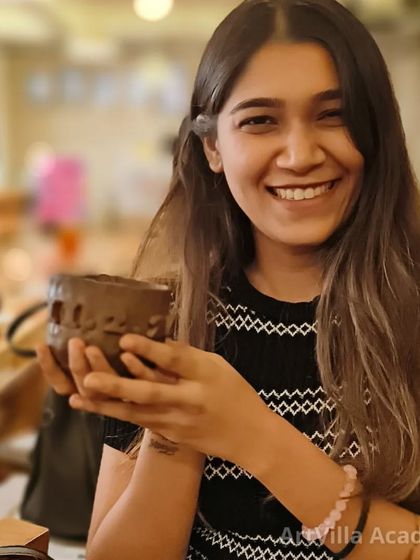 The proud smile of a new potter. This participant holds up the cup she crafted during our workshop, complete with her own unique carved designs.