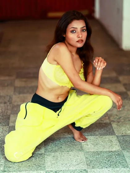 A playful and confident pose. The simple composition allows the bright colors and her energetic personality to shine.