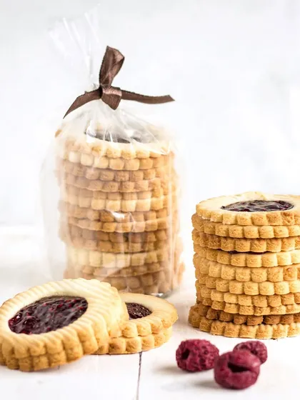 My buttery jam-ring cookies, with a sweet raspberry jam center. These are a nostalgic favorite, handcrafted with a scalloped edge for a classic patisserie look.