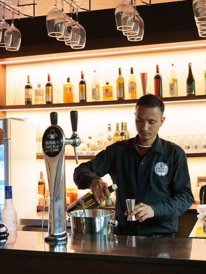 Our bartender preparing a drink. The bar at Ebisu is a place of craft, where we mix classic cocktails and Japanese-inspired beverages to complement your meal.