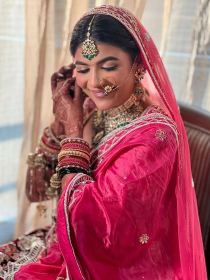 A beautiful candid of the bride adjusting her earring, giving a glimpse of her elegant bridal updo.