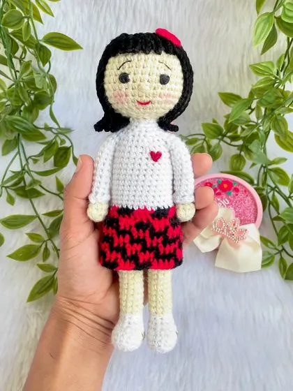 A replica doll of a sweet little girl in a skirt with a red and black pattern. I really enjoyed the challenge of the colorwork on the skirt to make it look just right.