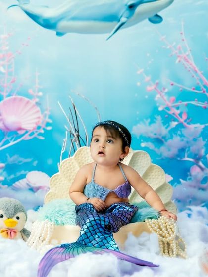 An ethereal underwater scene for a mermaid-themed shoot, with a beautiful blue backdrop, coral, and even a friendly whale swimming above.