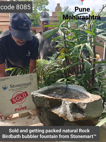 A natural rock birdbath fountain, marked as "Sold to Pune," awaits packing in our workshop.