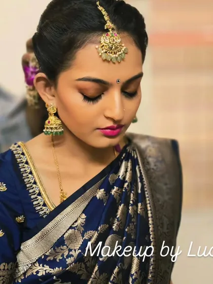 This is the classic South Indian festive look I created for a client's family ceremony. The focus is on flawless skin, defined eyes with a gold shimmer, and a bold pink lip to complement her royal blue silk saree.
