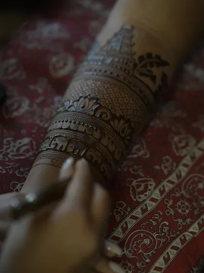 A macro shot showing the fine lines of a temple and elephant band being applied with precision.