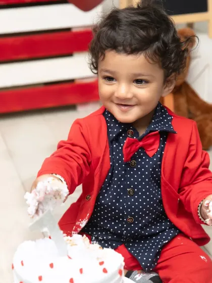 Getting ready to make a mess. This close-up captures the excitement in his eyes as he reaches for his first birthday cake during his Valentine's shoot.