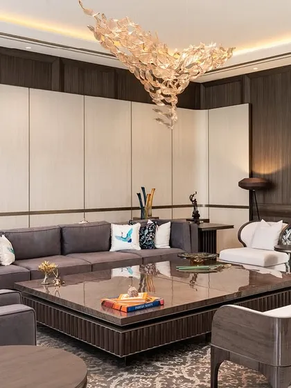 In this New Delhi farmhouse, we layered textures and forms to create a living space that is both warm and deeply sophisticated. The design features a custom wallpaper screen, Koto wood paneling, and a starburst-patterned center table, all harmonizing with the lush green views.