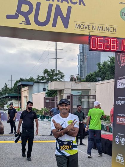 A participant crossing the finish line at the Farmley Snack Run, with the official race clock in the background. We ensure professional, timed results for our runners.