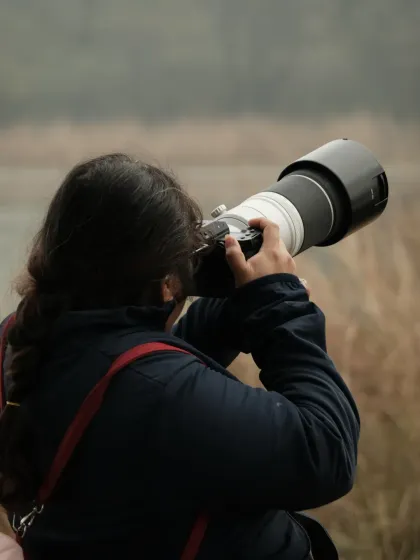 Me in my element, focused on the shot with a telephoto lens. This is where I am most comfortable, whether it's tracking wildlife or finding a story from afar.