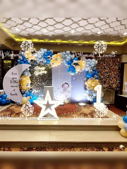 A wide shot of the space-themed stage, showing the full setup with the sequin backdrop, moon and star props, and an astronaut cutout.