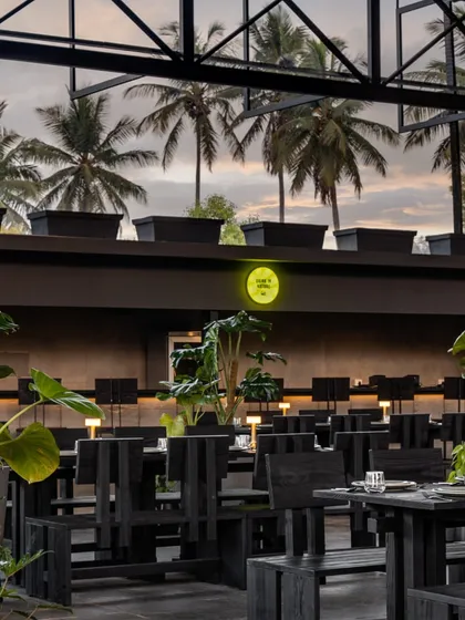 From inside our dining area, you get a stunning view of the palm trees against the evening sky. I designed the space with large glass panels so you always feel connected to the nature outside.