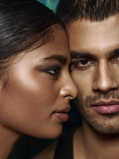 'Love/25'. An intimate couple's portrait where the focus is on the connection and proximity of the two models. The lighting is soft and flattering, creating a gentle mood.