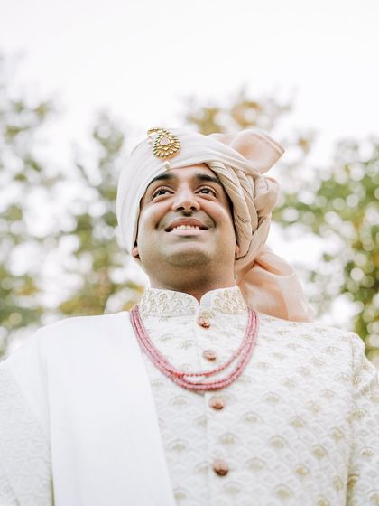 A low-angle shot of the groom looking up with a smile, exuding confidence and joy.