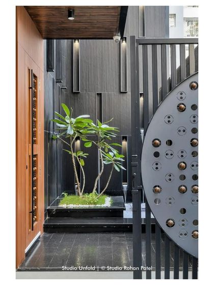 The entrance gate and wall feature custom metalwork with circular motifs, offering a hint of the detailed design language within.