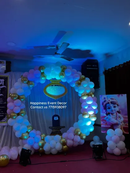 A modern ring backdrop I created for a naming ceremony. The large circular frame is covered with white, pink, and gold balloons, with a custom nameplate hanging in the center.