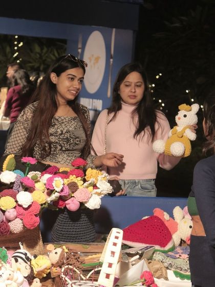 Guests browsing a stall with handmade crochet items at the World Food Carnival. Our festivals often include lifestyle and craft pop-ups alongside the food stalls.