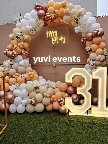 A slightly different angle of the 31st birthday outdoor setup, showing the full half-moon shape of the balloon arch. The mix of matte and metallic balloons gives the decoration a rich texture.