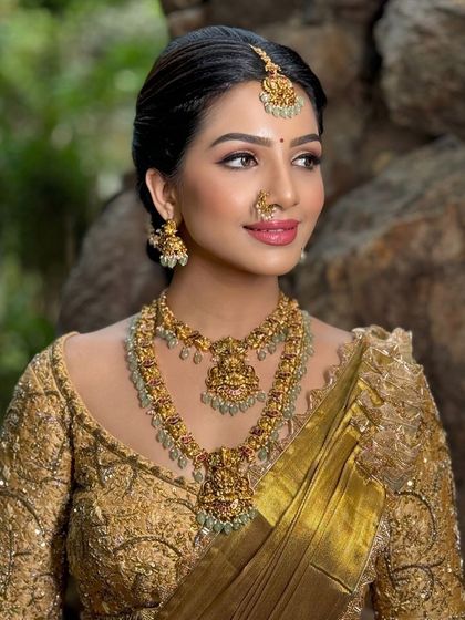 A beautiful model shoot featuring a golden half-saree. The makeup is glamorous, with a focus on defined eyes and a radiant complexion.