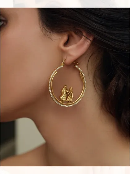 Whimsical and unique, these hoop earrings feature a small dancing couple motif inside a diamond-studded ring.