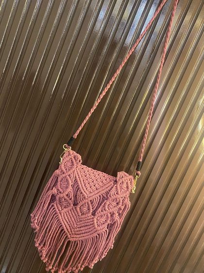 A full view of the dusty pink macrame sling bag, showing the braided strap and the detailed V-shaped flap design. All my bags are made with washable cotton cord.