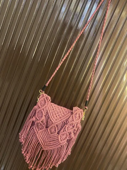 A full view of the dusty pink macrame sling bag, showing the braided strap and the detailed V-shaped flap design. All my bags are made with washable cotton cord.